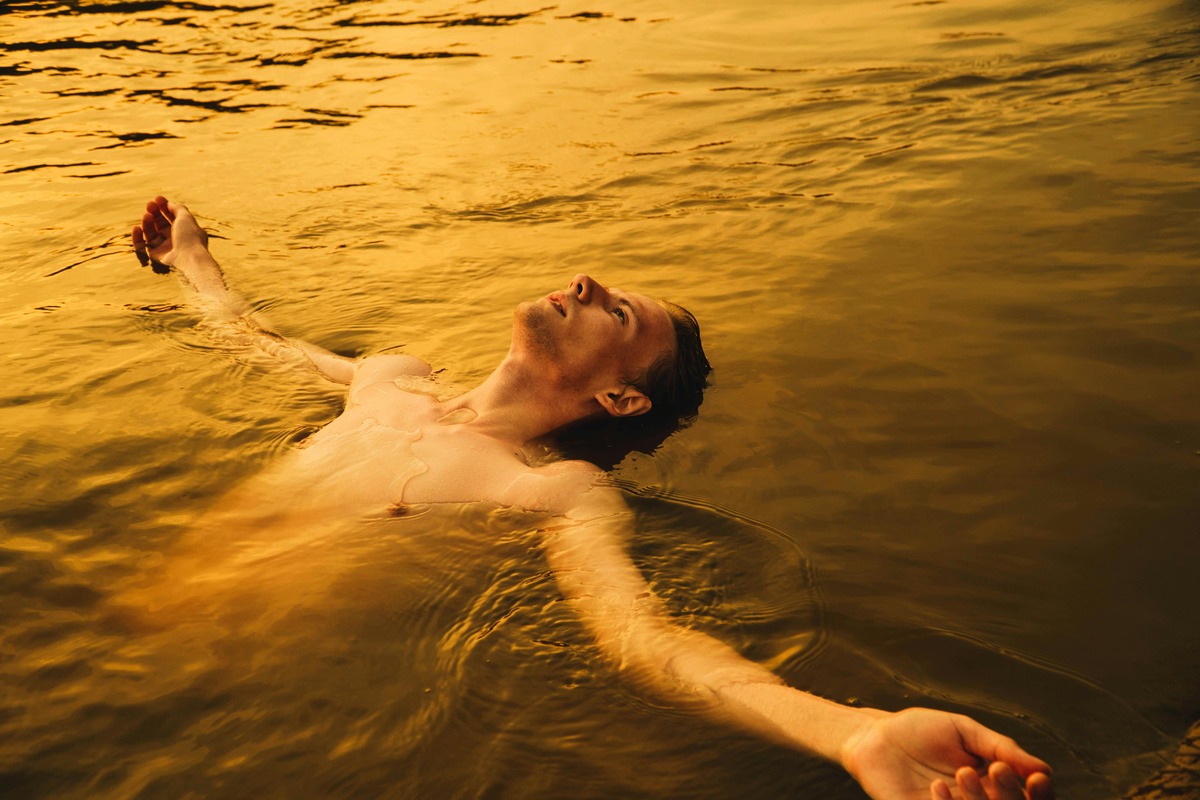 Achtsam sein. Mann, genussvoll im Wasser treibend.